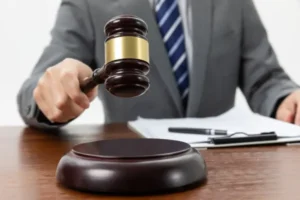 A judge about to strike a gavel on a wooden table.