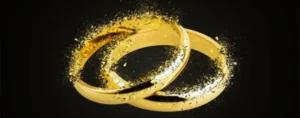Two golden wedding rings resting on a black background.