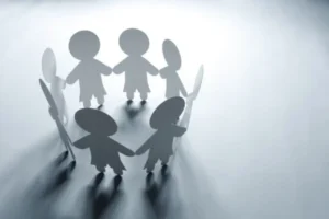 Paper cutouts of people forming a circle, holding hands in unity.
