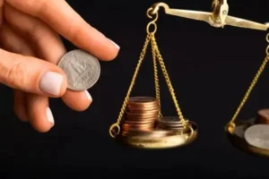 A person holding a coin and a balance scale, symbolizing fairness and financial decision-making.