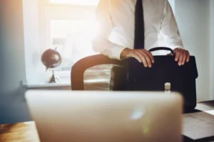 A professional man in formal attire holds a briefcase, ready for business.