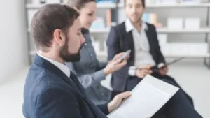 Three professionals discussing work in a meeting room.