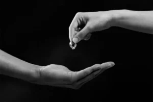 A hand giving a ring to another hand