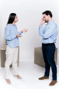 A man and woman having a discussion in front of boxes.