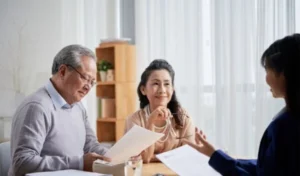 A couple having a discussion with a professional advisor in a meeting room.