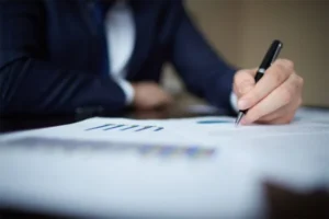 Businessman in suit writing on paper.