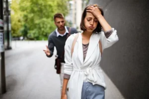 A couple having a conversation while strolling down a city street.