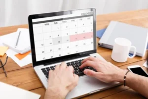 A person using a calendar app on a laptop.