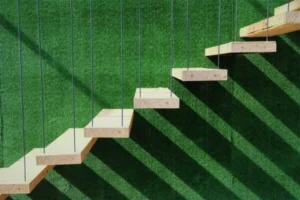 A set of wooden stairs against a green wall.