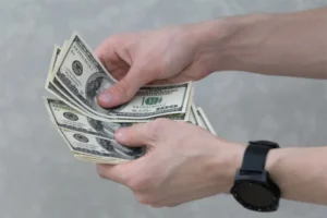 A person holding a stack of cash in their hand