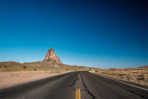 A desert road with a distant mountain.