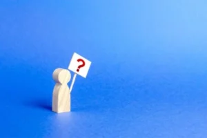 Man holding a question sign on blue background.
