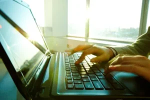 A person typing on a laptop computer.