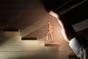 A person climbing stairs next to a hand.