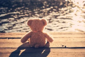 A teddy bear sitting on a dock