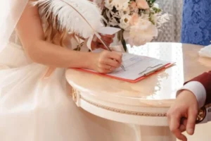 A bride and groom signing their marriage certificate