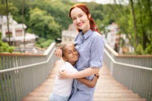 A woman and child embrace on a bridge