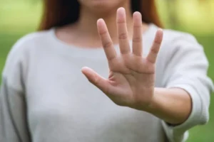 A woman displaying her hand, indicating a clear signal to halt or cease any action.