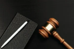 A gavel placed next to a notebook and pen.