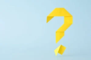 A paper question mark set against a blue background