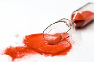 A broken hourglass with red sand spilling out