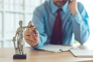 A man is holding a statue placed on his wooden table