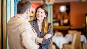 A woman is folding her arms across her chest while looking at the man