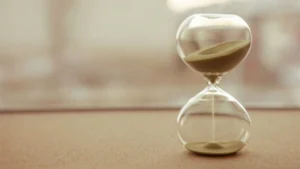 An hourglass containing brown sand.