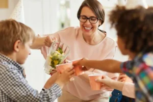 A woman is pouring a drink for her two young boys