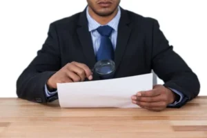 A man in a suit examining a document.