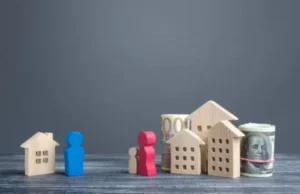 a wooden figure of house and man with money